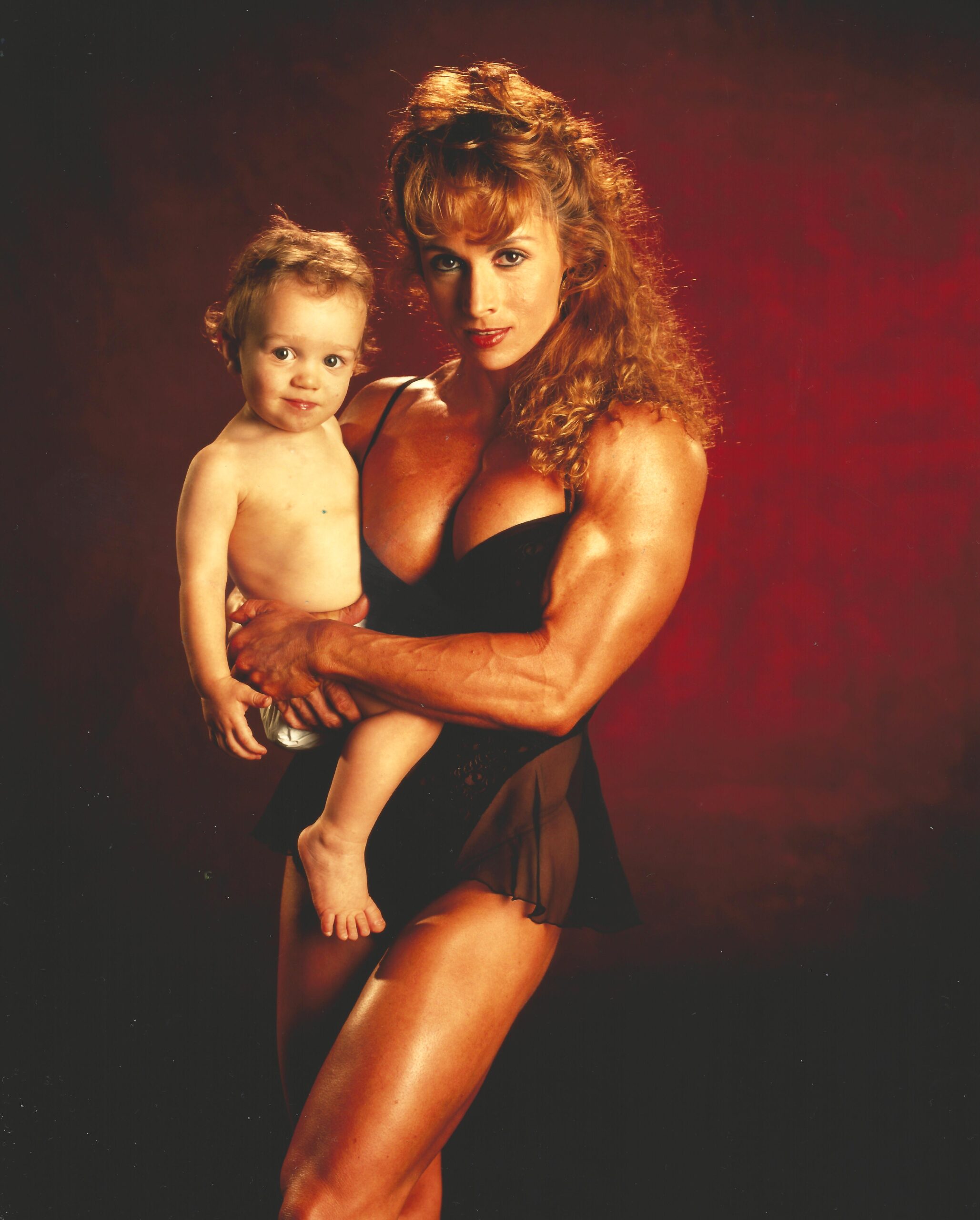 Deb McKnight IFBB Pro holding infant son, Bill Dobbins photo shoot