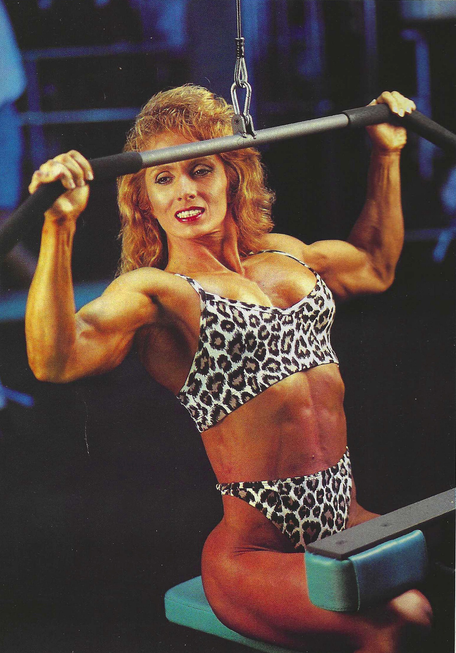 Deb McKnight IFBB Pro on the lat pulldown machine in a two piece leopard outfit.