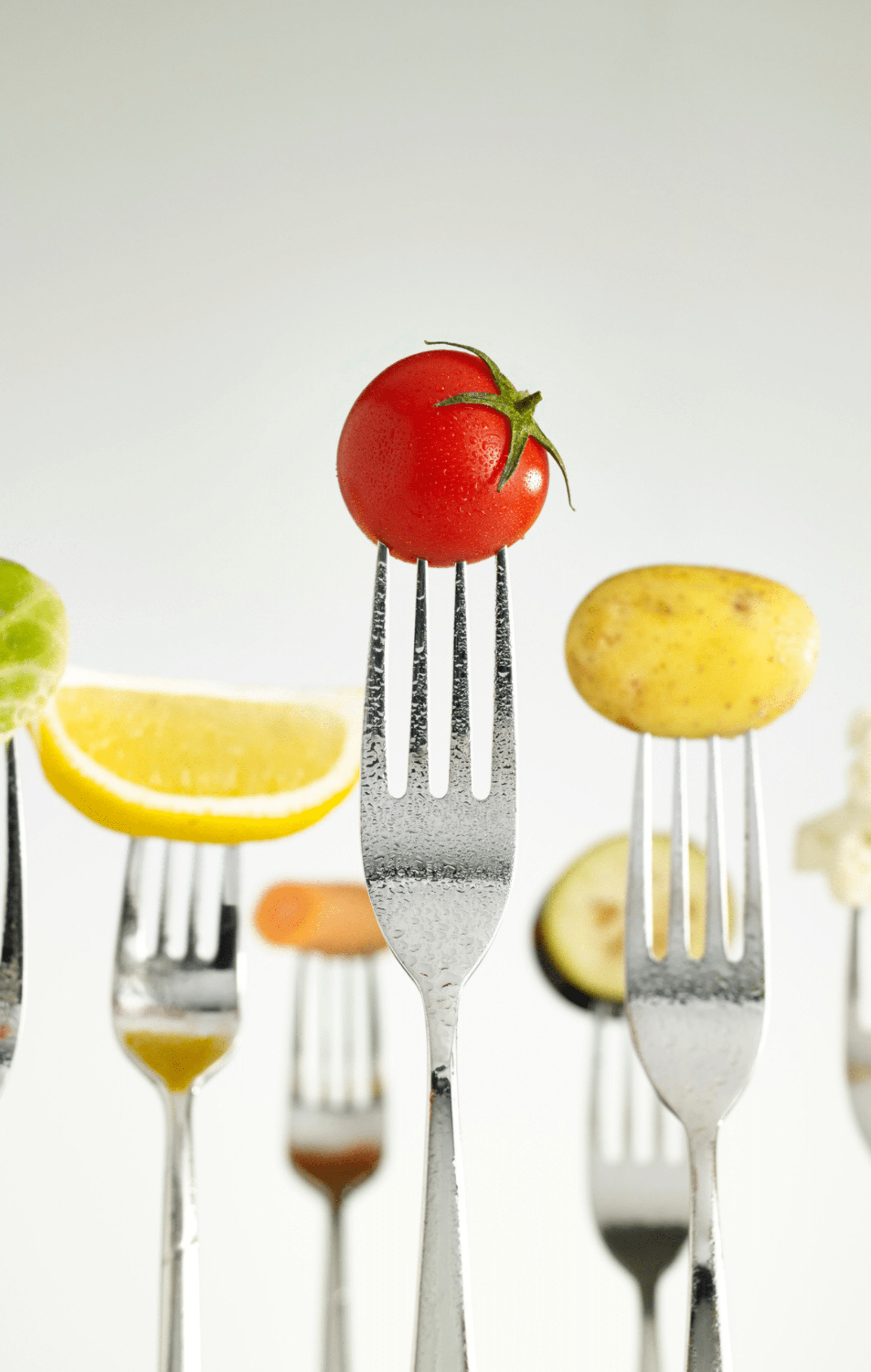 Fruits and vegetable pieces each on the end of an individual fork.