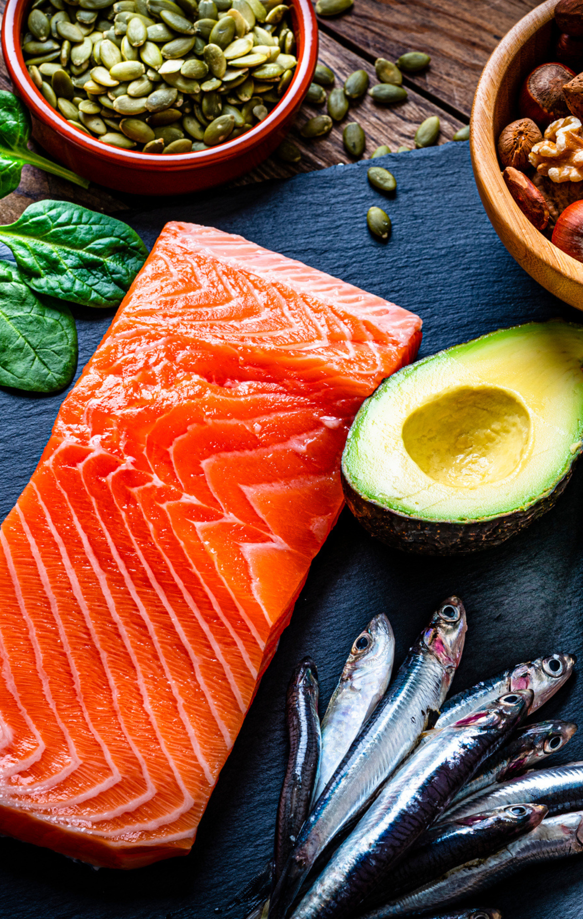 Image of healthy fats like sardines, avocados, nuts, seeds, and salmon.