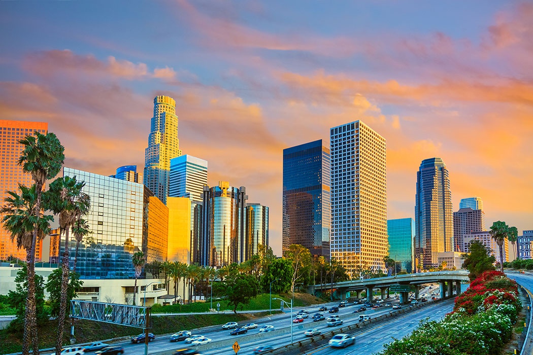 Gleeming tall buildings and freeway under a colorful sky in Downtown Los Angeles