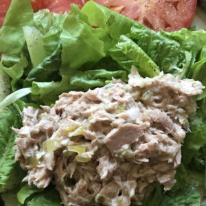 Scoop of tuna salad on lettuce with tomatoes