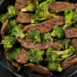 Close-up image of beef and broccoli stir fry in a cast iron skillet