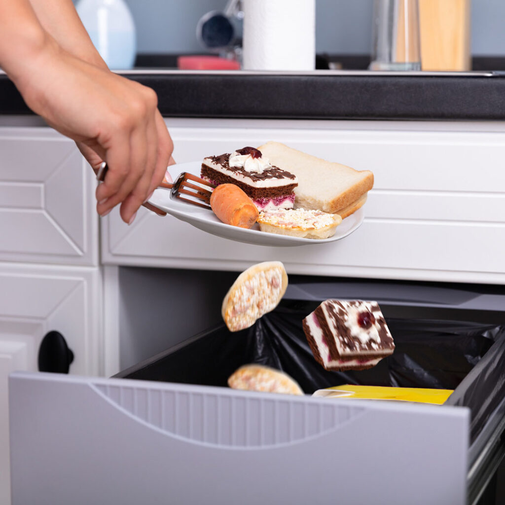 Image showing hands scraping various sweets into the trash bin