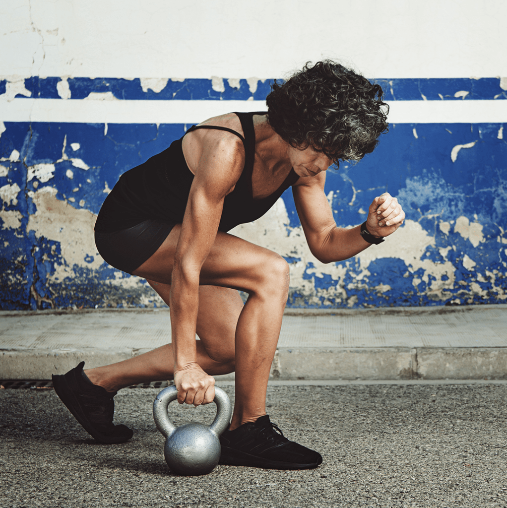Lean athletic woman using a kettlebell to exercise